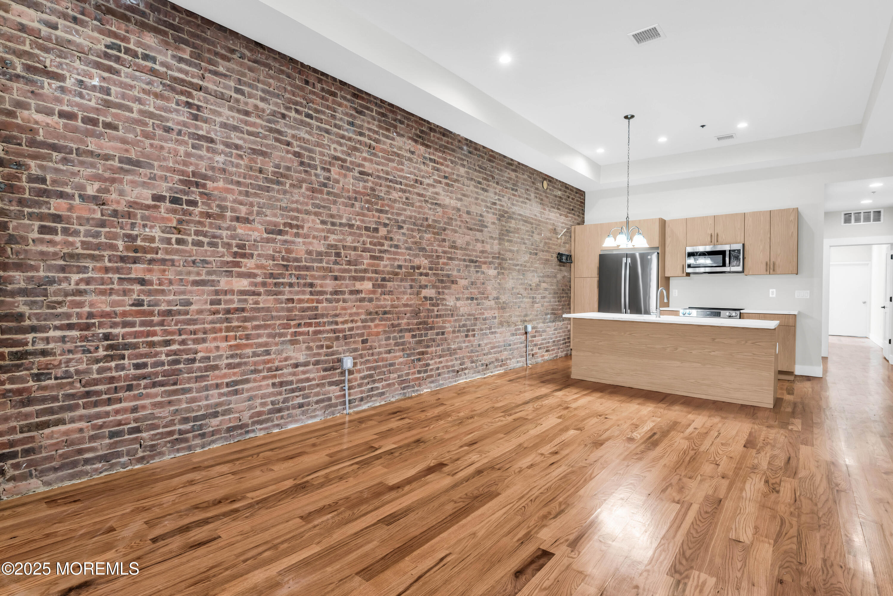 7 Broad Street, Unit 1 Red Bank, NJ 07701 - Photo 5 of 28 a view of a kitchen with stainless steel appliances wooden floor and cabinets