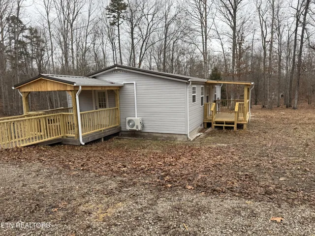 a view of a house with a yard and wooden fence