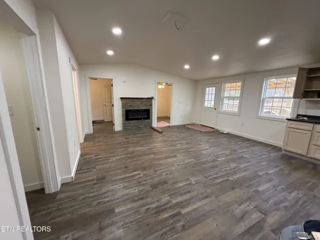a large kitchen with kitchen island granite countertop a stove top oven a sink a counter space and cabinets