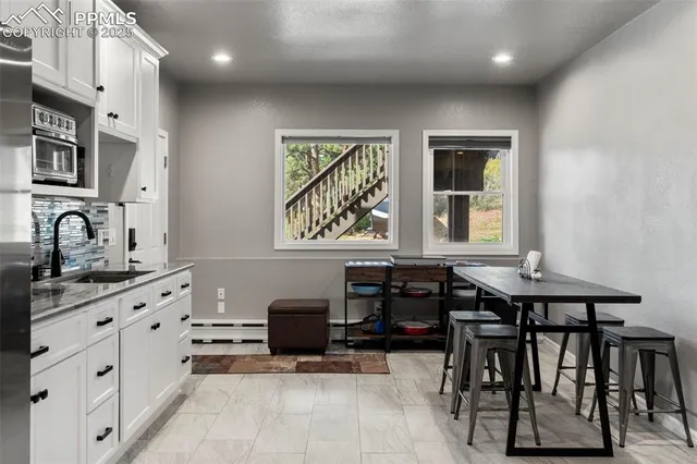 a living room with furniture flat screen tv and large refrigerator