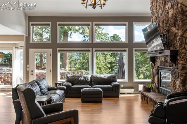 a living room with furniture large windows and wooden floor