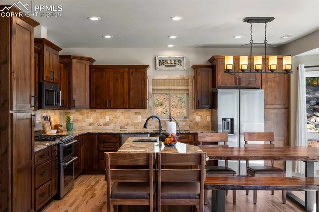 a kitchen with a dining table chairs stainless steel appliances and cabinets