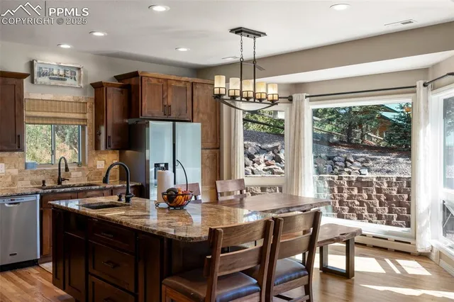 a kitchen with granite countertop a sink and a refrigerator