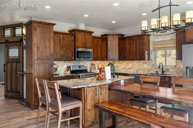 a kitchen with kitchen island granite countertop wooden cabinets and a refrigerator