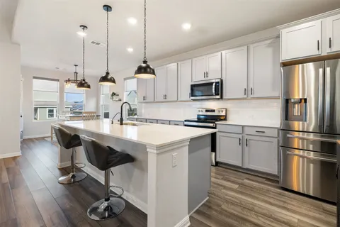 a kitchen with kitchen island stainless steel appliances a sink and cabinets