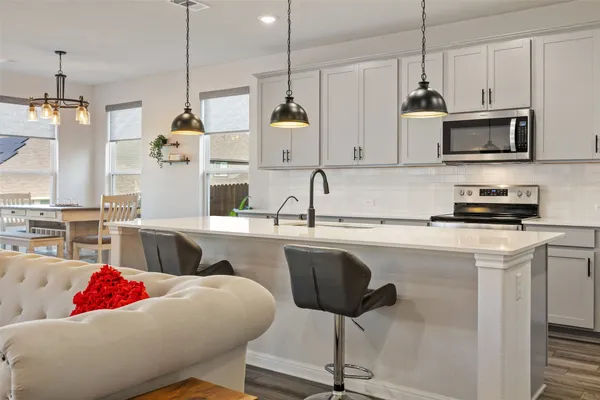 a kitchen with stainless steel appliances kitchen island granite countertop a sink and a refrigerator