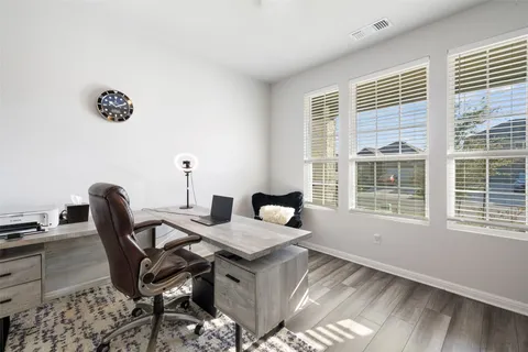 a view of a workspace with furniture and a window