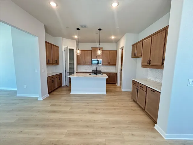 a large kitchen with cabinets and stainless steel appliances