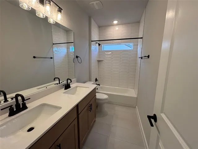 a bathroom with a sink a toilet a mirror and shower