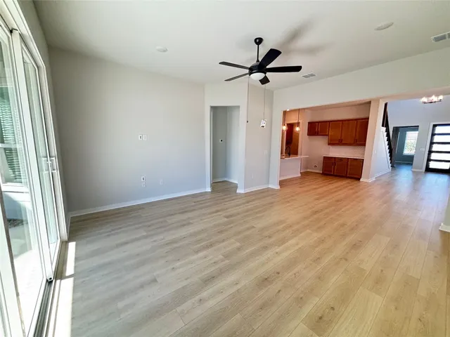 a view of empty room with wooden floor and window