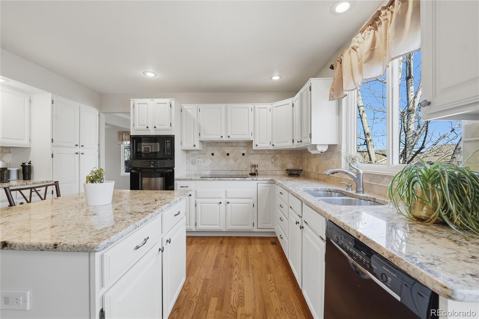 9264 Madras Court Highlands Ranch, CO 80130 - Photo 12 of 50 a kitchen with a sink a stove and cabinets