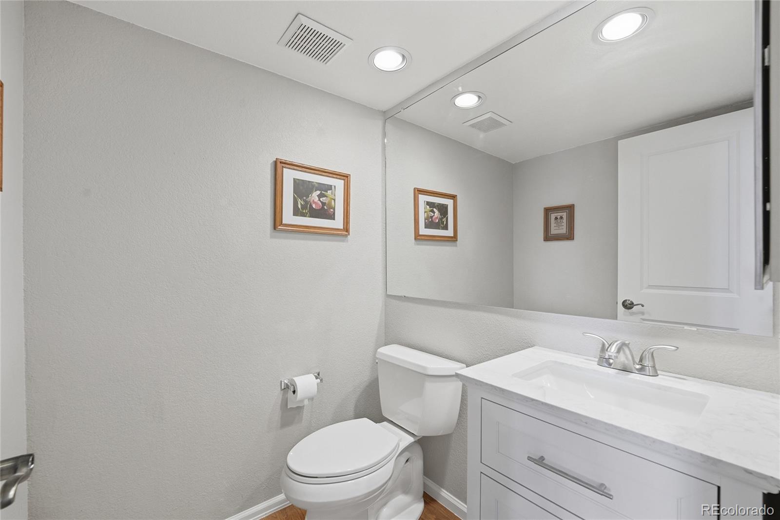9264 Madras Court Highlands Ranch, CO 80130 - Photo 17 of 50 a bathroom with a toilet a sink and mirror