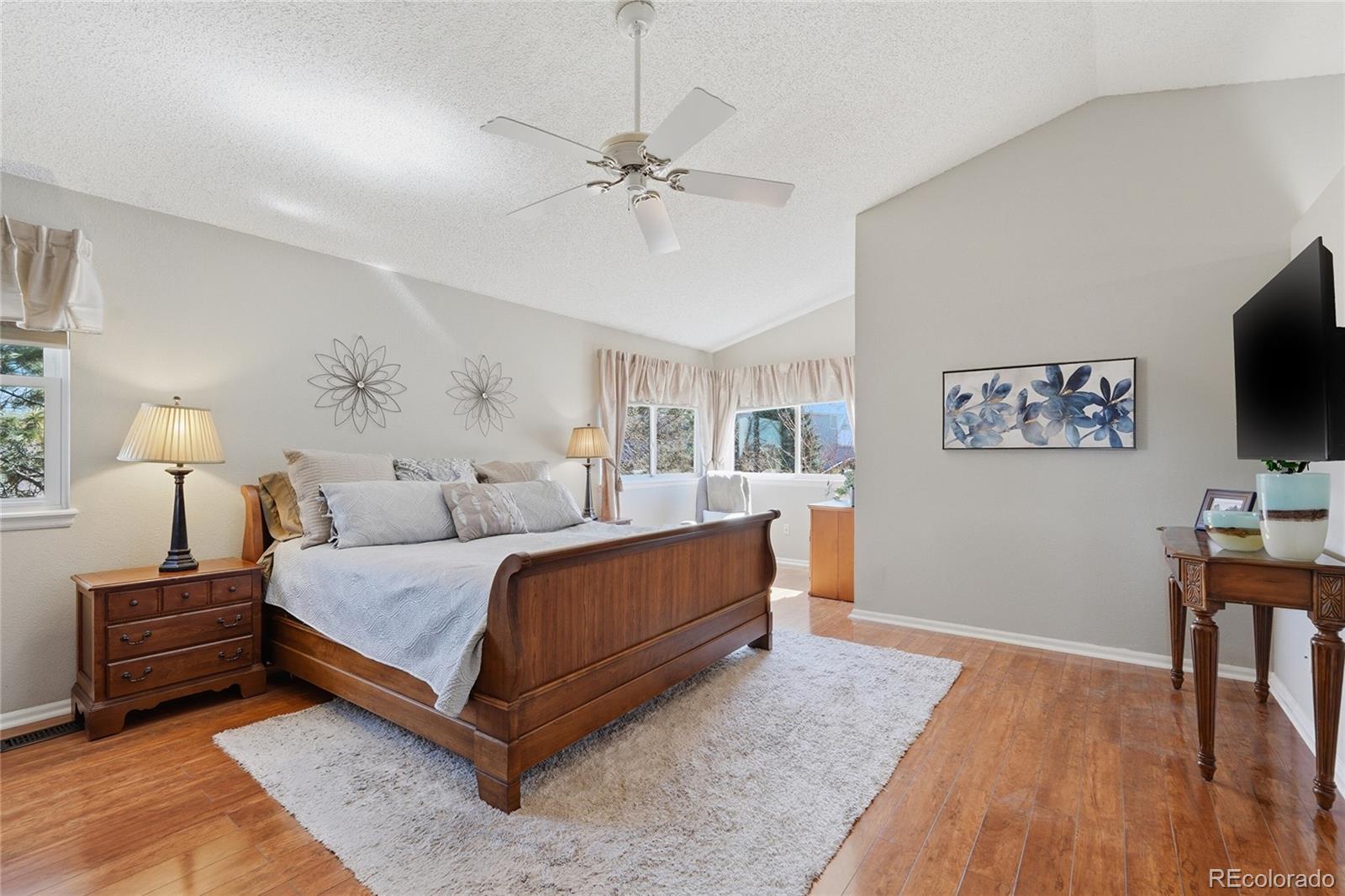 9264 Madras Court Highlands Ranch, CO 80130 - Photo 19 of 50 a bedroom with a bed and a flat screen tv
