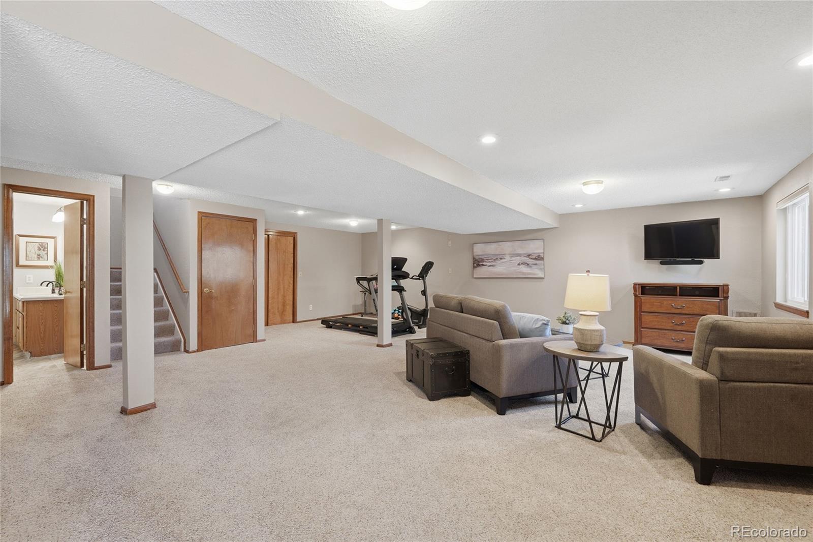 9264 Madras Court Highlands Ranch, CO 80130 - Photo 29 of 50 a living room with furniture and a flat screen tv