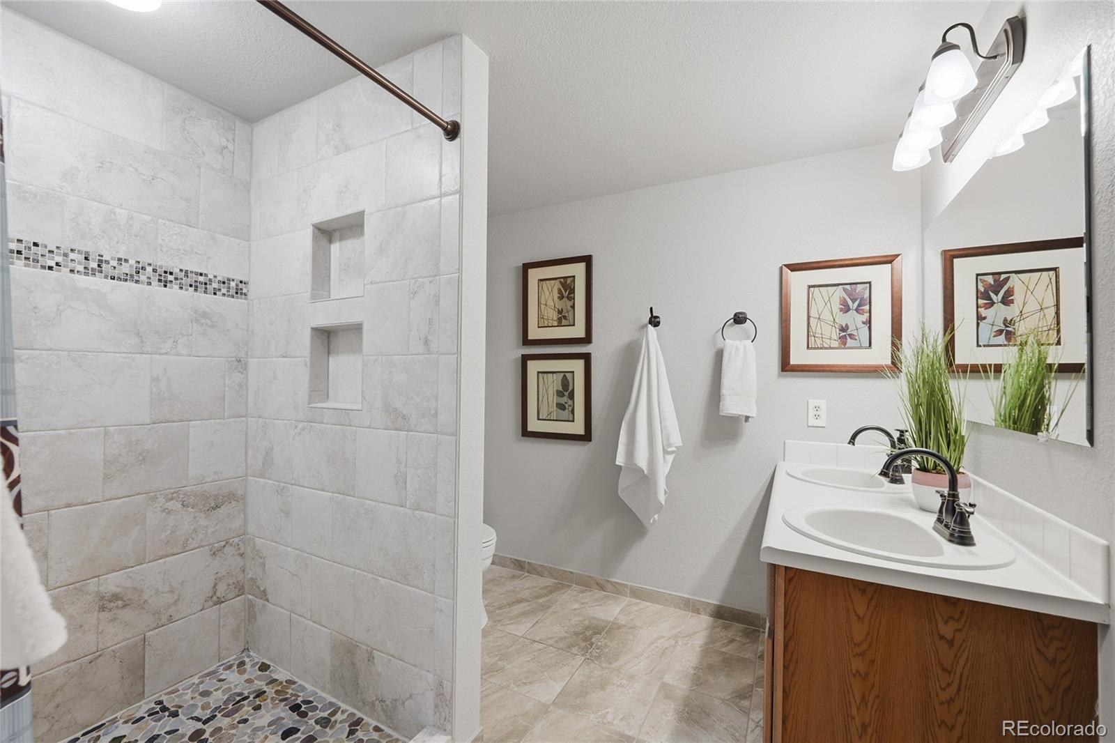9264 Madras Court Highlands Ranch, CO 80130 - Photo 31 of 50 a bathroom with a sink a mirror and a shower