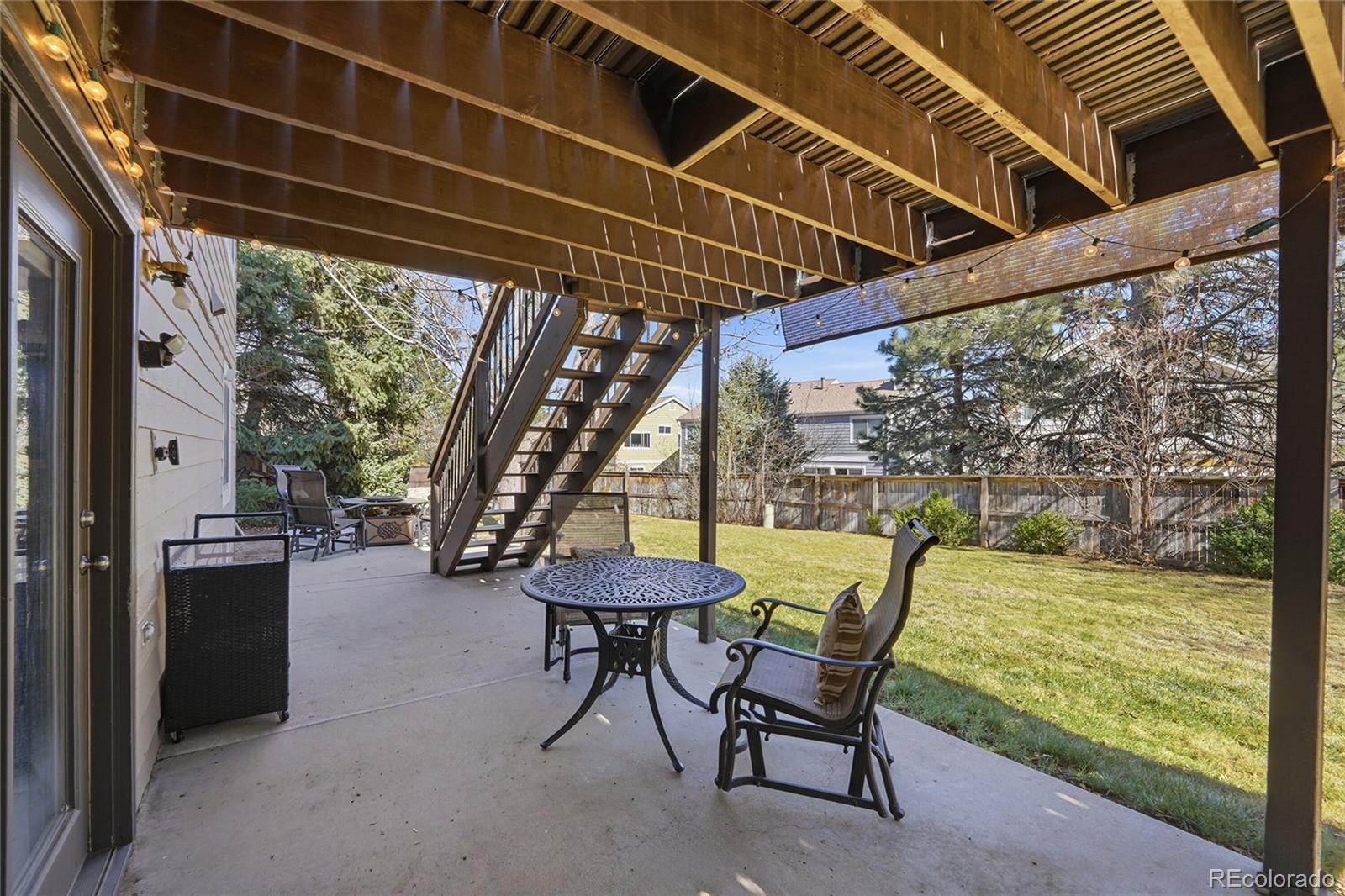 9264 Madras Court Highlands Ranch, CO 80130 - Photo 34 of 50 a view of a chairs and table in the patio next to a yard