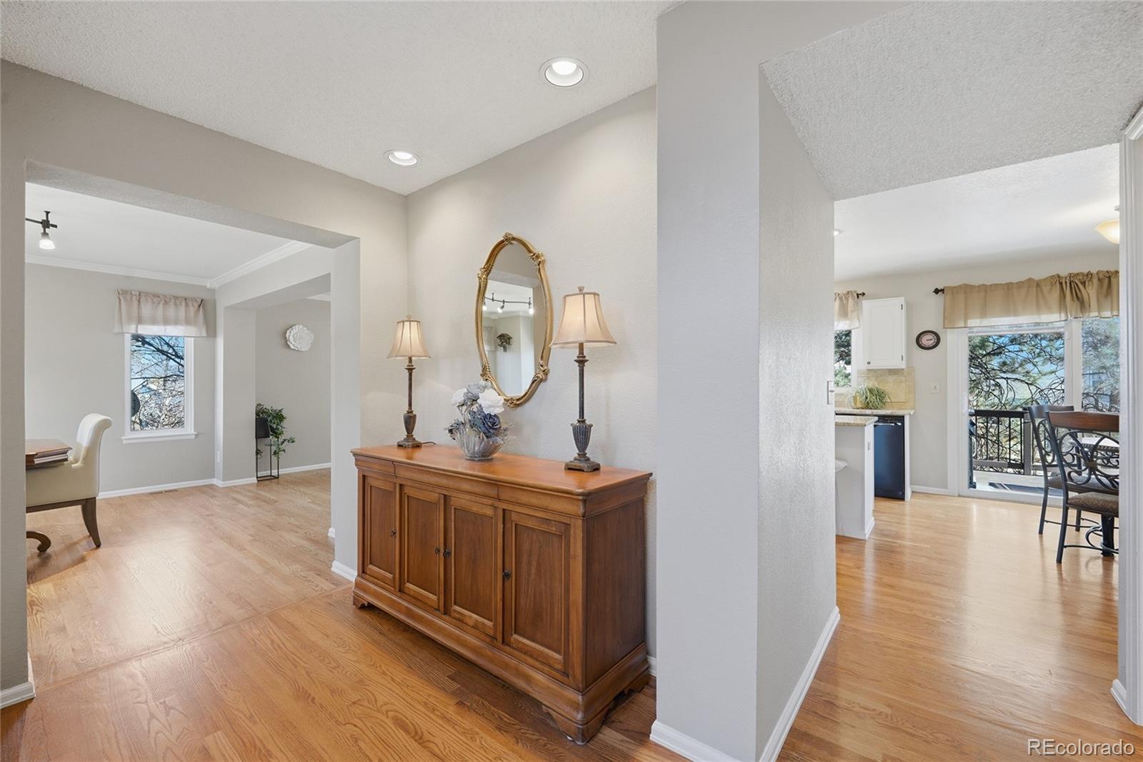 9264 Madras Court Highlands Ranch, CO 80130 - Photo 7 of 50 a view of a livingroom with furniture wooden floor a fireplace and a chandelier