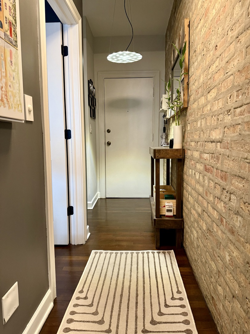4720 North Beacon Street, Unit 2N Chicago, IL 60640 - Photo 16 of 26 a view of a bedroom with wooden floor and a rug