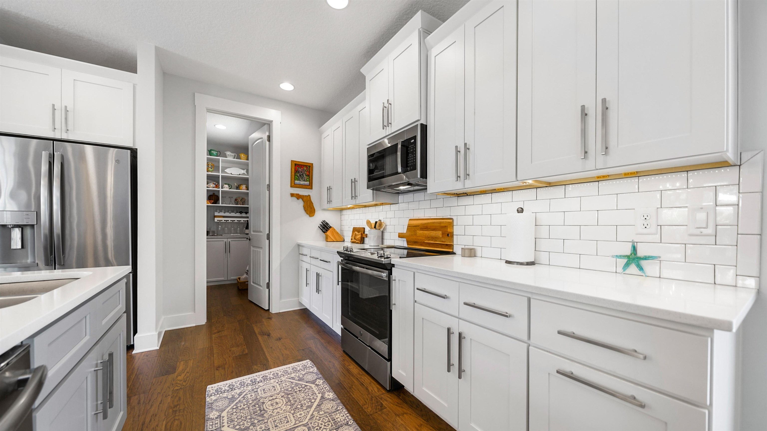 304 Ribault Street St. Augustine, FL 32080 - Photo 20 of 69 a kitchen with cabinets stainless steel appliances a sink and wooden floor