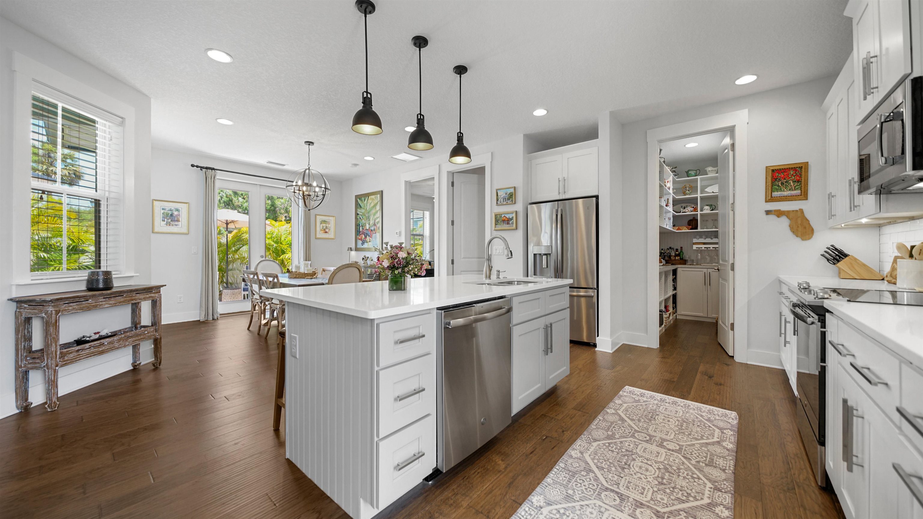 304 Ribault Street St. Augustine, FL 32080 - Photo 6 of 69 a large kitchen with stainless steel appliances kitchen island granite countertop a refrigerator a stove a sink dishwasher and white cabinets with wooden floor