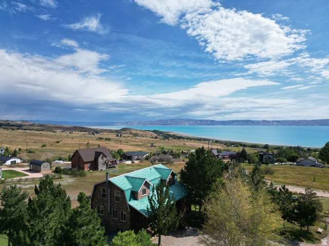 358 Maple Drive Fish Haven, ID 83287 - Photo 42 of 46 Property featuring a multi-level structure with a green metal roof, stone exterior, and surrounding natural landscape with distant water and mountain backdrops