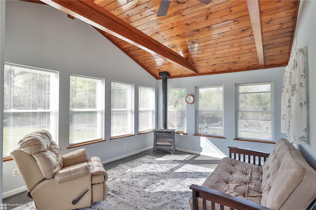 205 West Moorestown Road Wind Gap, PA 18091 - Photo 6 of 20 Sun-filled room boasts a vaulted wood ceiling and a freestanding fireplace for cozy gatherings.