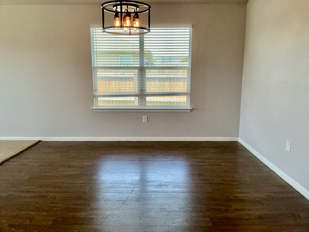12040 Riparian Road Manor, TX 78653 - Photo 7 of 23 Warm wood-look flooring and an industrial-style light fixture anchor this versatile dining space.