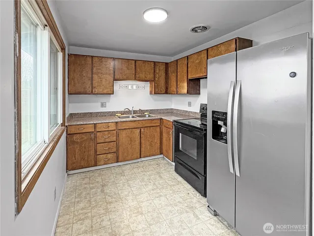 a kitchen with stainless steel appliances granite countertop a refrigerator and a sink