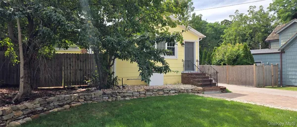 a view of backyard with potted plants and wooden fence