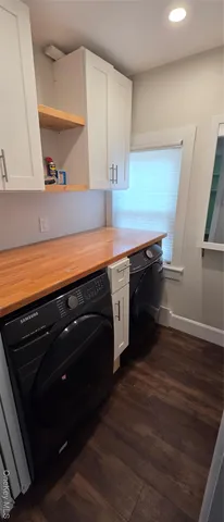 a kitchen with stainless steel appliances and wooden floor