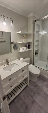 a bathroom with a sink a toilet a mirror and shower