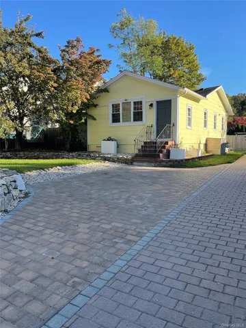 a view of a house with a yard and a large tree