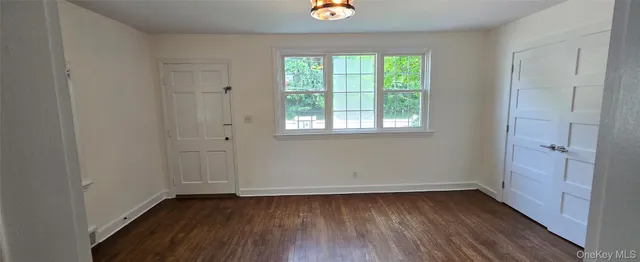 an empty room with wooden floor and window