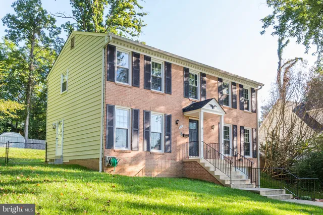 a front view of a house with a yard and trees