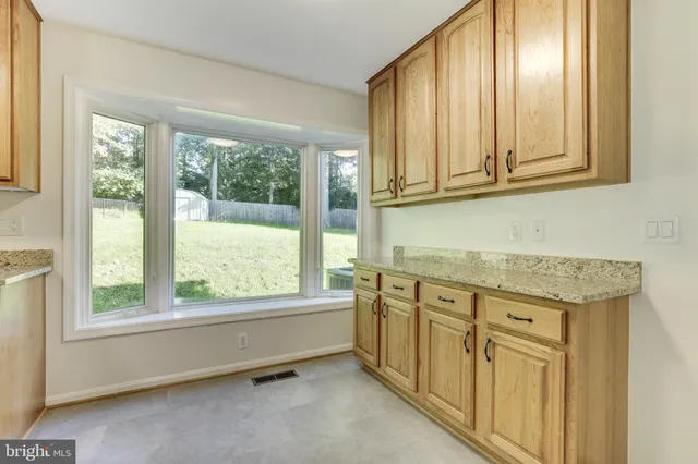 a view of an empty room with a fireplace and a window