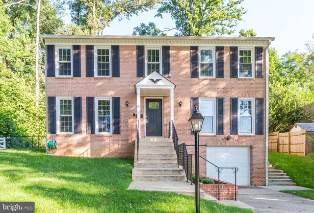 front view of a brick house with a yard table and chairs