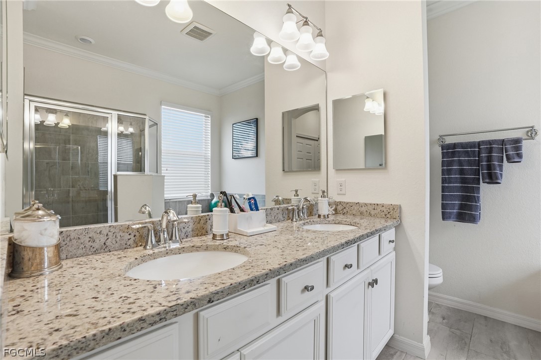 1936 Wellington Street Naples, FL 34120 - Photo 15 of 27 a bathroom with a granite countertop double vanity sink and a mirror