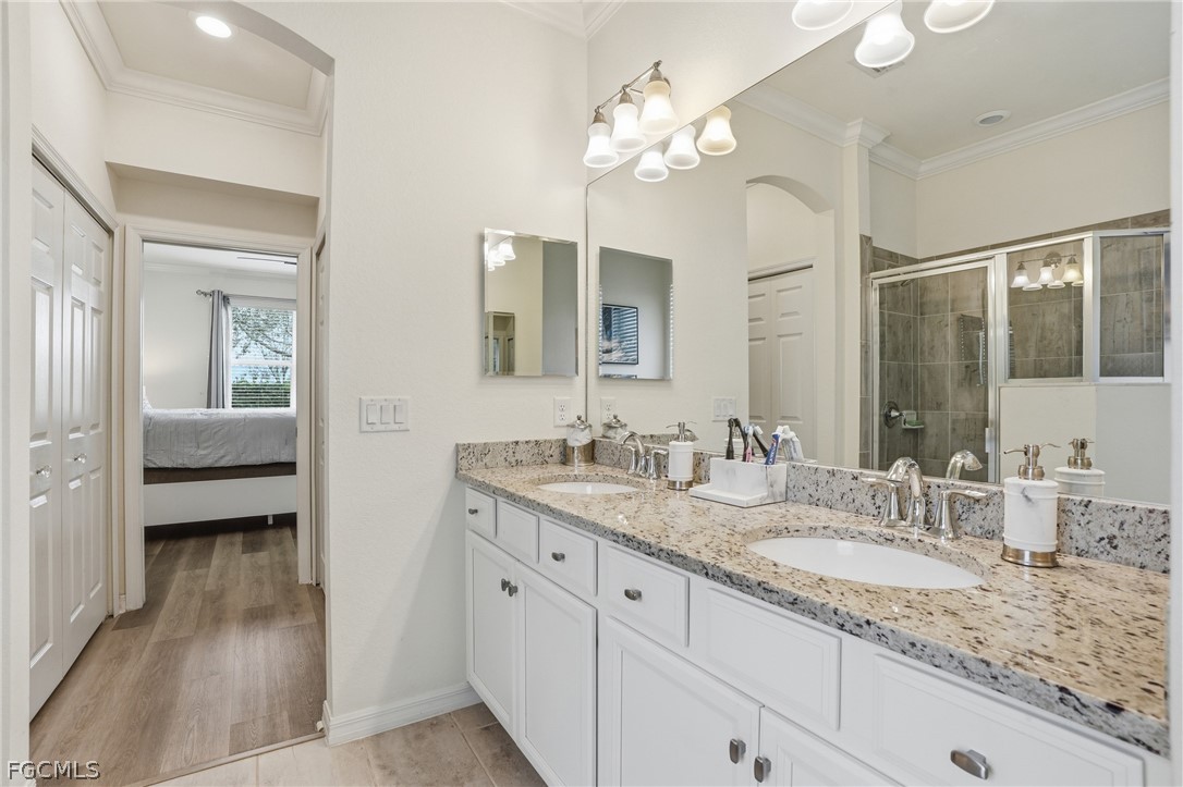 1936 Wellington Street Naples, FL 34120 - Photo 16 of 27 a en suite bathroom with a granite countertop double vanity sink a mirror a vanity and a bathtub