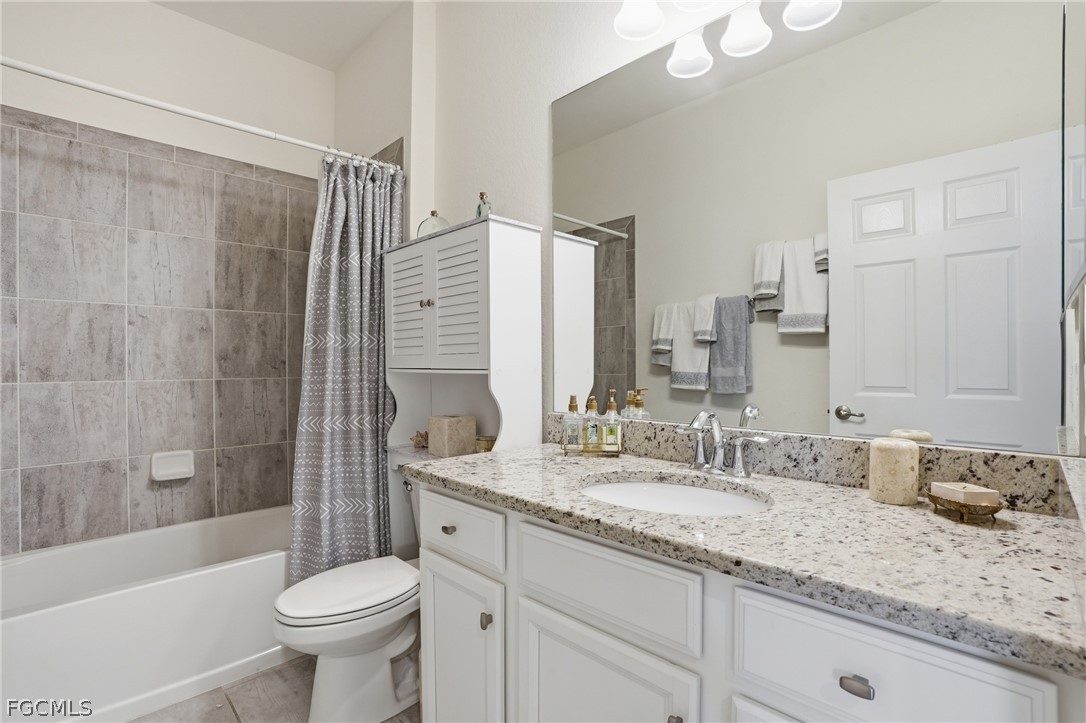 1936 Wellington Street Naples, FL 34120 - Photo 21 of 27 a bathroom with a granite countertop sink toilet mirror and bathtub