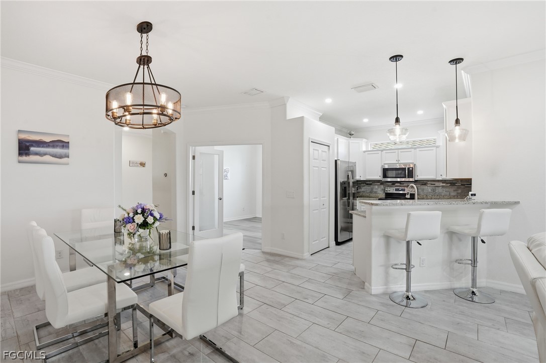 1936 Wellington Street Naples, FL 34120 - Photo 6 of 27 a dining room filled chandelier and kitchen view