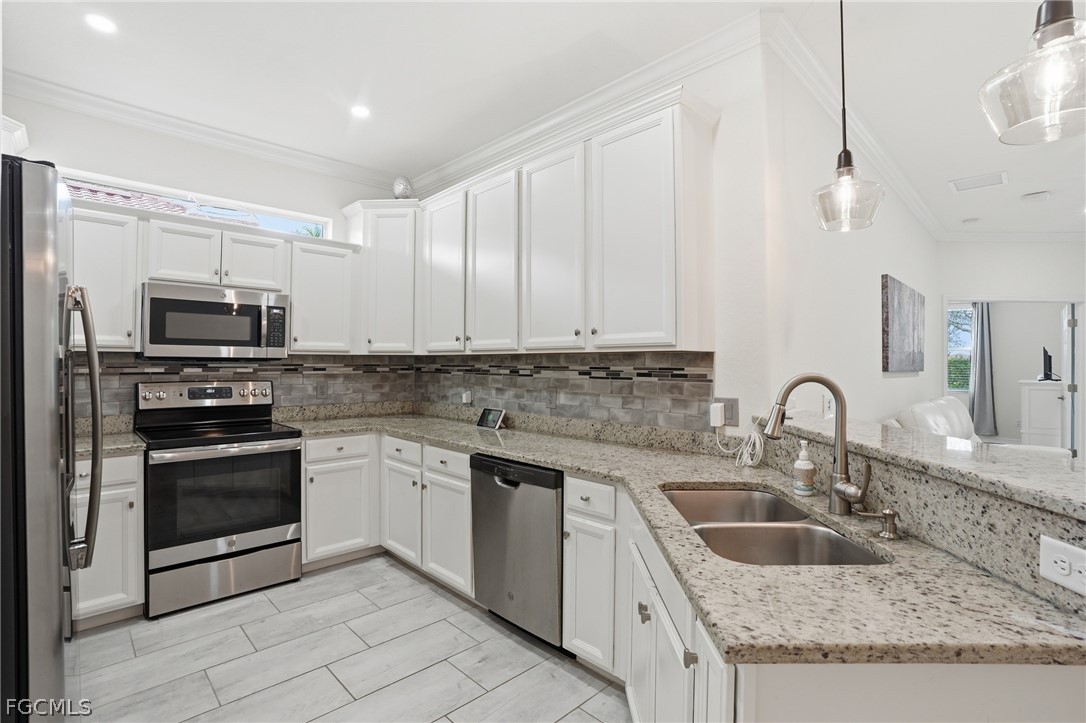 1936 Wellington Street Naples, FL 34120 - Photo 7 of 27 a kitchen with granite countertop a sink stainless steel appliances and cabinets