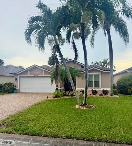 a view of a house with a yard and palm trees