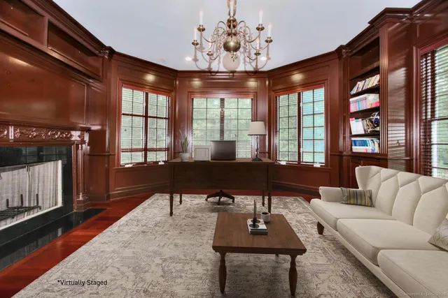 a living room with furniture a chandelier and a floor to ceiling window