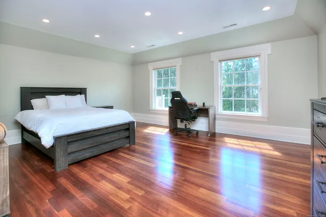 a bedroom with a bed and wooden floor