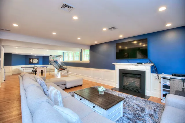 a living room with furniture a fireplace and a flat screen tv