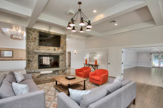 a living room with furniture a flat screen tv and a fireplace