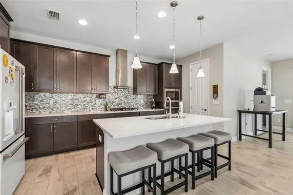 a kitchen with kitchen island a sink stove and refrigerator