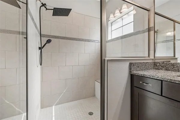 a bathroom with a granite countertop sink a toilet and a mirror