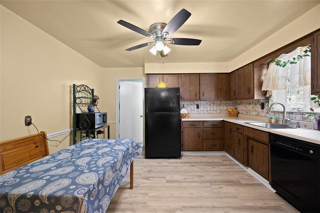 1421 Fleming Avenue McKees Rocks, PA 15136 - Photo 7 of 36 a kitchen with a refrigerator a sink and dishwasher with wooden cabinets