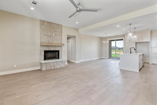 a large kitchen with granite countertop a large center island a sink stainless steel appliances and cabinets